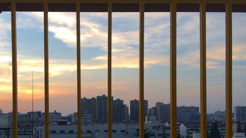 Modern cityscape against sky during sunset