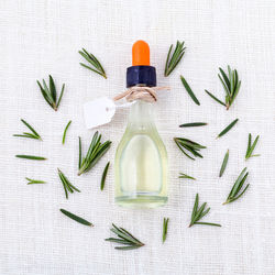 Directly above shot of bottle amidst rosemary on table