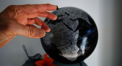 Close-up of person holding cigarette against gray background
