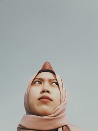 Low angle portrait of a sculpture against gray background