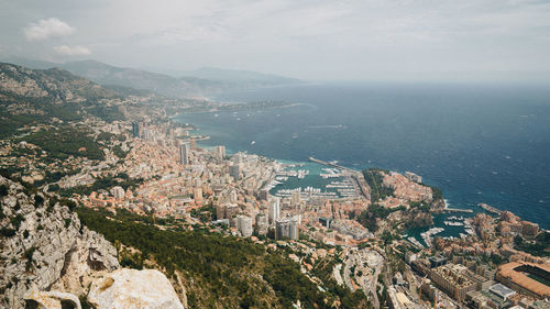 High angle view of cityscape by sea against sky