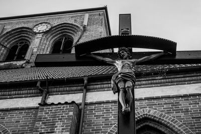 Low angle view of statues on building against sky