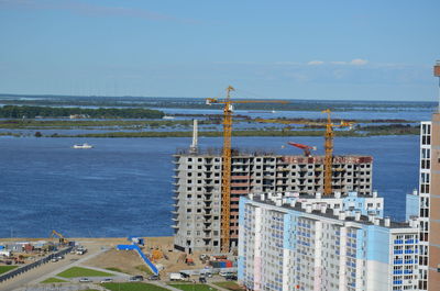 High angle view of sea and buildings against sky