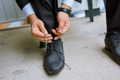 Low section of man tying shoes