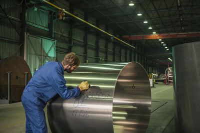 Worker labeling metal in factory