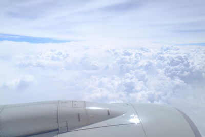 View of airplane wing over clouds