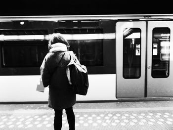 Rear view of woman against train