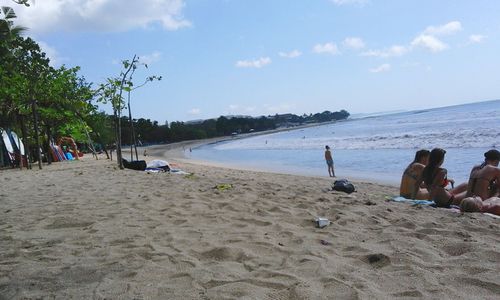 People on beach against sky