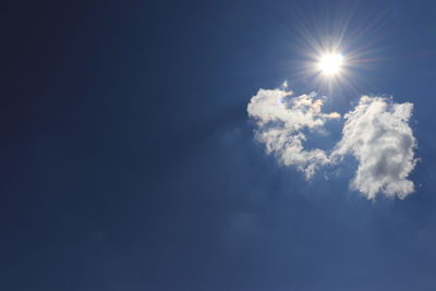 Low angle view of bright sun in sky