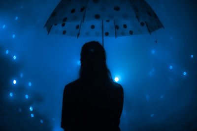 Rear view of silhouette woman standing at music concert