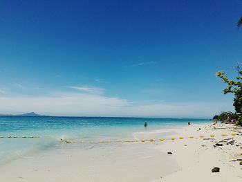 Scenic view of beach against blue sky