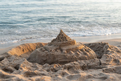 Sand castle on the background of the sea in the light of the sunset.