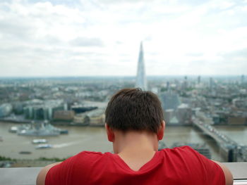 Rear view of man looking at cityscape