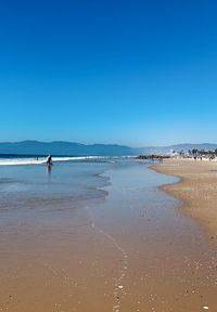 Scenic view of beach against clear blue sky