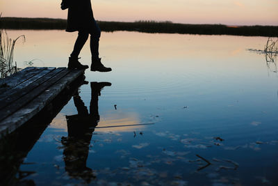 Person stepping on lake at dusk