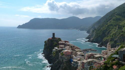 Scenic view of sea by mountains against sky