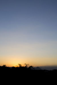 Silhouette landscape against clear sky during sunset