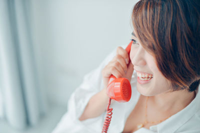 Close-up of smiling woman talking on telephone