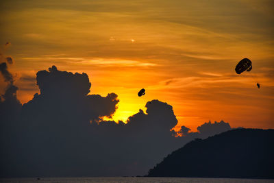 Silhouette hot air balloon against sky during sunset