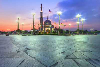 Panoramic view of illuminated commercial dock against sky during sunset