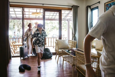 Happy family entering resort villa during vacation