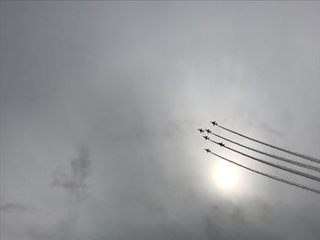 Low angle view of silhouette airplane against sky