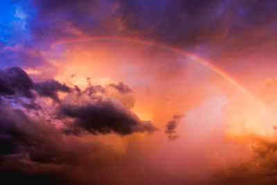 Low angle view of rainbow in sky at sunset