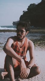 Young man sitting on beach