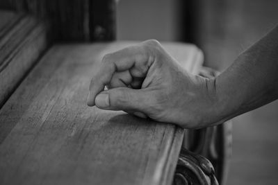 Close-up of man hand on wood at home