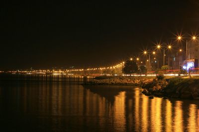 Illuminated cityscape against sky at night