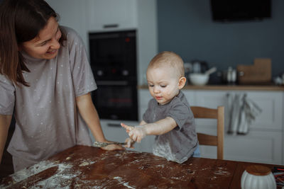 Smiling mother and cute boy with flour on face