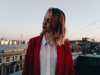 Young woman looking at city against sky