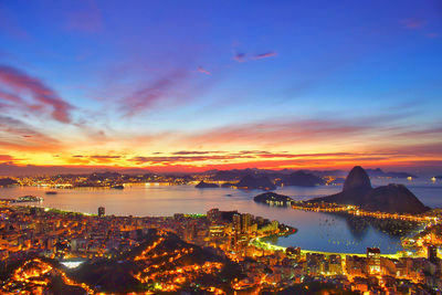 High angle view of illuminated residential district and guanabara bay at dusk