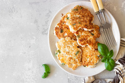 Juicy homemade chicken cutlets on a ceramic plate with basil and sour cream. 