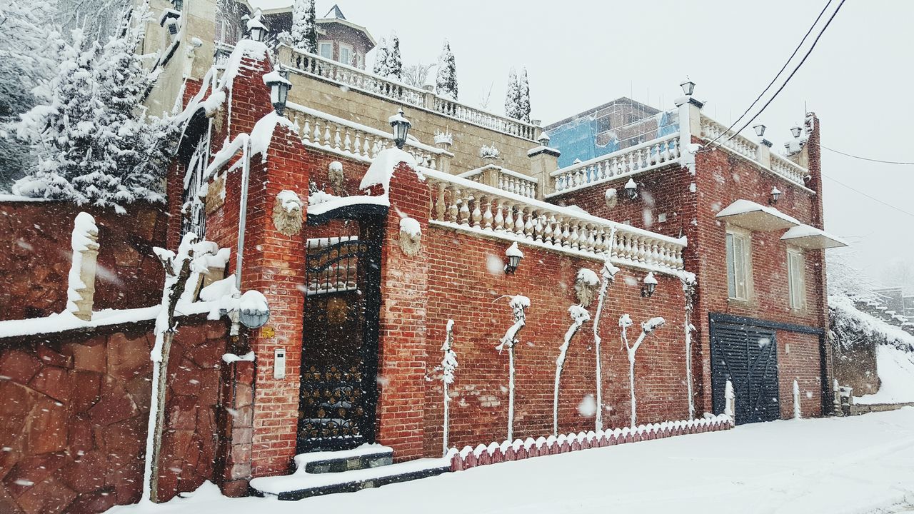 building exterior, architecture, built structure, snow, winter, cold temperature, season, low angle view, weather, day, house, outdoors, sky, residential structure, brick wall, building, no people, residential building, wall - building feature, covering