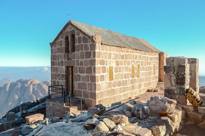 Stone wall of church against clear blue sky