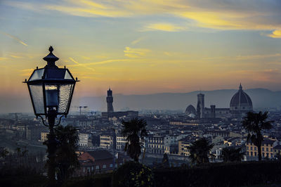 Distant view of duomo santa maria del fiore against sky in city during sunset