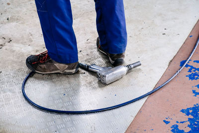 Low section of man with tool on ground