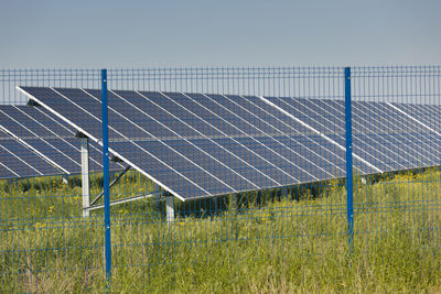 Electricity pylon on field against clear sky