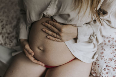 Pregnant woman holding hands on belly