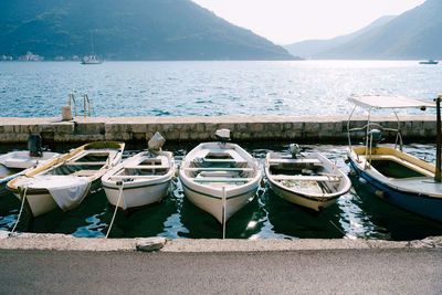 Boats moored in sea against mountains