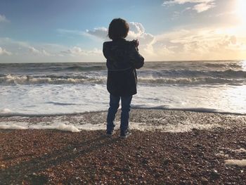 Rear view of man standing on beach