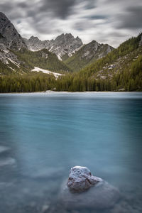 Scenic view of lake by mountain against sky