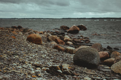 Pebbles on beach against sky