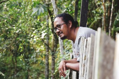 Side view of young man looking away in forest