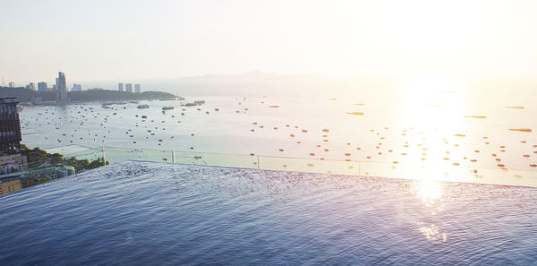 Scenic view of sea and buildings against sky during sunset