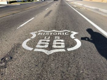 Shadow of man by information sign on road