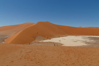 Scenic view of desert against clear blue sky