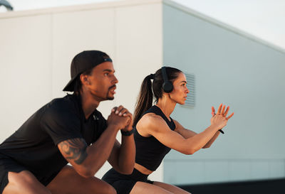 Side view of young woman exercising at home