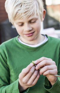 Little boy examining bud outdoors